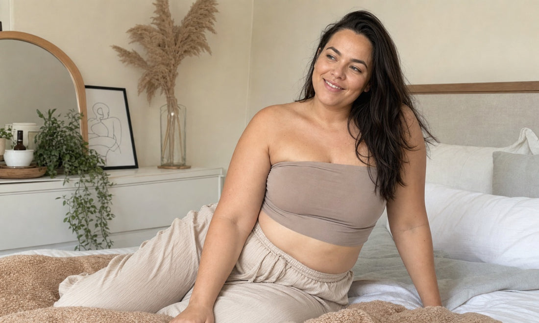 Woman with a fuller figure relaxing at home in a neutral strapless bandeau and loungewear